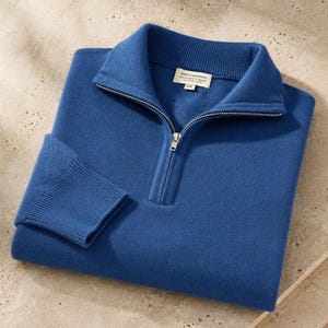 Peut inclure: Un pull bleu à fermeture éclair quart, doté d'un col et de poignets côtelés, d'une fermeture éclair en métal argenté et d'une étiquette intérieure blanche indiquant 100% Cashmere, Handcrafted in Nepal, Dry Clean Only, XXL.