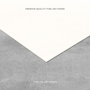 Pode incluir: Close-up de um papel de arte fino branco texturizado com o texto "PREMIUM QUALITY FINE ART PAPER" impresso em preto. O papel est&aacute; sobre uma superf&iacute;cie cinza texturizada. O texto "&copy; HELIOS ART PRINTS" est&aacute; impresso em preto na parte inferior da imagem.