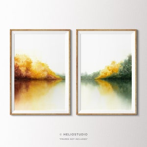Könnte beinhalten: Zwei Aquarelle, die eine Landschaft mit einem See und Bäumen in Gelb-, Grün- und Brauntönen darstellen. Die Bilder sind in einem hellen Holzrahmen gerahmt.