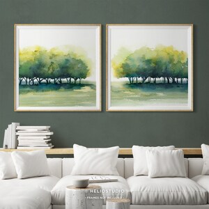 Pode incluir: Um conjunto de duas pinturas de aquarela emolduradas que retratam uma fileira de &aacute;rvores em uma paisagem verde e amarela. As pinturas est&atilde;o em molduras de madeira e est&atilde;o penduradas em uma parede verde.