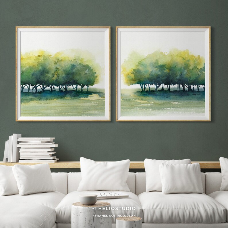 Pode incluir: Um conjunto de duas pinturas de aquarela emolduradas que retratam uma fileira de &aacute;rvores em uma paisagem verde e amarela. As pinturas est&atilde;o em molduras de madeira e est&atilde;o penduradas em uma parede verde.