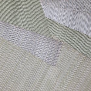 May include: Abstract image of overlapping textured paper sheets in shades of green, grey, and off-white. The sheets have a linear pattern, creating a geometric design. The overall effect is a modern, minimalist aesthetic.