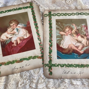 May include: Two vintage Christmas cards featuring illustrations of children with their pets. The first card shows a girl holding a white cat, with the text "Sing a Song." The second card shows a girl sleeping with a dog, with the text "A little rest I'll get."
