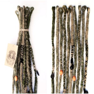 Puede incluir: Un conjunto de rastas sintéticas verdes y marrones con costuras negras y marrones. Las rastas están atadas juntas con una cuerda marrón y tienen cuentas de madera y abalorios negros.