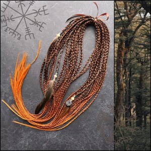 May include: A set of brown and orange ombre synthetic hair braids with beads and feathers. The braids are tied together with a brown ribbon.