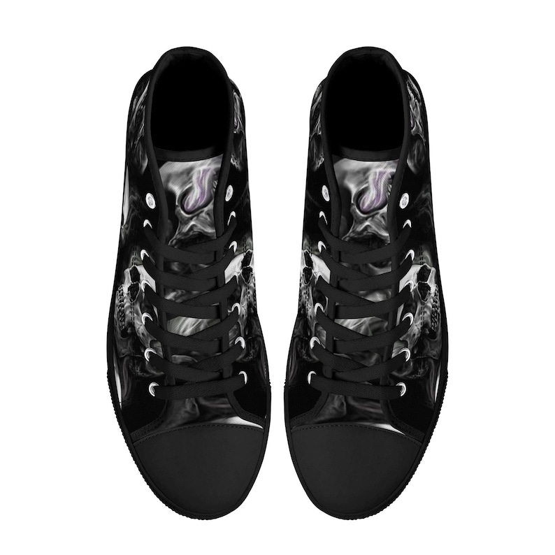 May include: A pair of black high-top canvas shoes with a white and gray abstract design. The shoes have black laces and a white rubber sole.