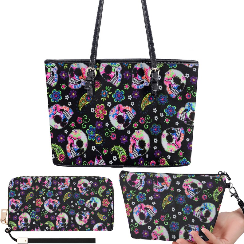May include: A black tote bag, a matching wallet, and a cosmetic bag with a colorful sugar skull pattern. The skulls are surrounded by flowers and paisley designs.