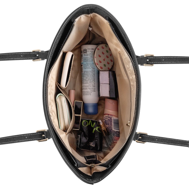 May include: Black tote bag with a zipper closure and two top handles. The bag is open and filled with various personal items, including makeup, skincare products, and a small wallet.