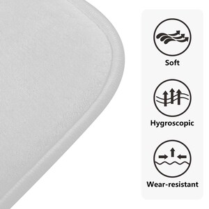 Puede incluir: Primer plano de una alfombra de ba&ntilde;o blanca, suave y absorbente, con un borde ligeramente elevado. La alfombra est&aacute; dise&ntilde;ada para ser c&oacute;moda, absorbente y duradera.