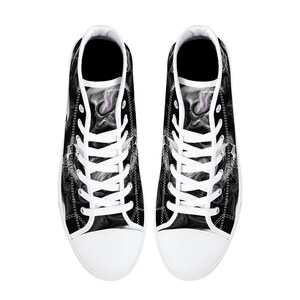 May include: A pair of black and white high-top canvas shoes with a smoke-like design. The shoes have white laces and a white rubber sole.