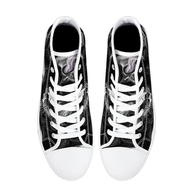 May include: A pair of black and white high-top canvas shoes with a smoke-like design. The shoes have white laces and a white rubber sole.