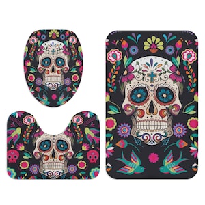 Puede incluir: Un juego de tres alfombras de ba&ntilde;o con un dise&ntilde;o de calavera de az&uacute;car colorida con detalles florales. El juego incluye una tapa para el inodoro, una alfombra de contorno y una alfombra de ba&ntilde;o.