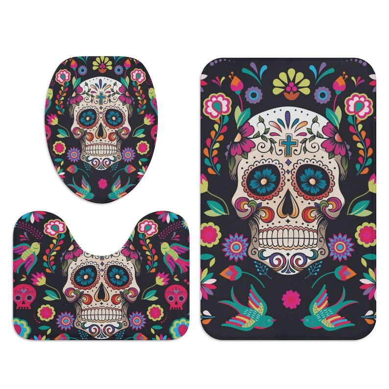 Puede incluir: Un juego de tres alfombras de ba&ntilde;o con un dise&ntilde;o de calavera de az&uacute;car colorida con detalles florales. El juego incluye una tapa para el inodoro, una alfombra de contorno y una alfombra de ba&ntilde;o.