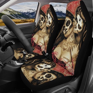 Puede incluir: Dos fundas de asiento de coche negras con un diseño colorido que presenta a dos mujeres con caras de calavera y tatuajes intrincados. El diseño incluye flores y enredaderas rojas, rosas y blancas.