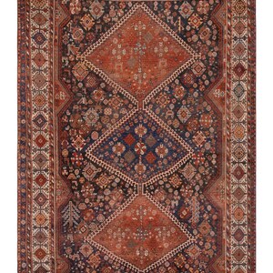 May include: An antique Persian rug with a complex geometric design. The rug features a central diamond pattern in shades of rust and navy blue, surrounded by a detailed border. The intricate patterns and rich colors create a classic, timeless aesthetic.