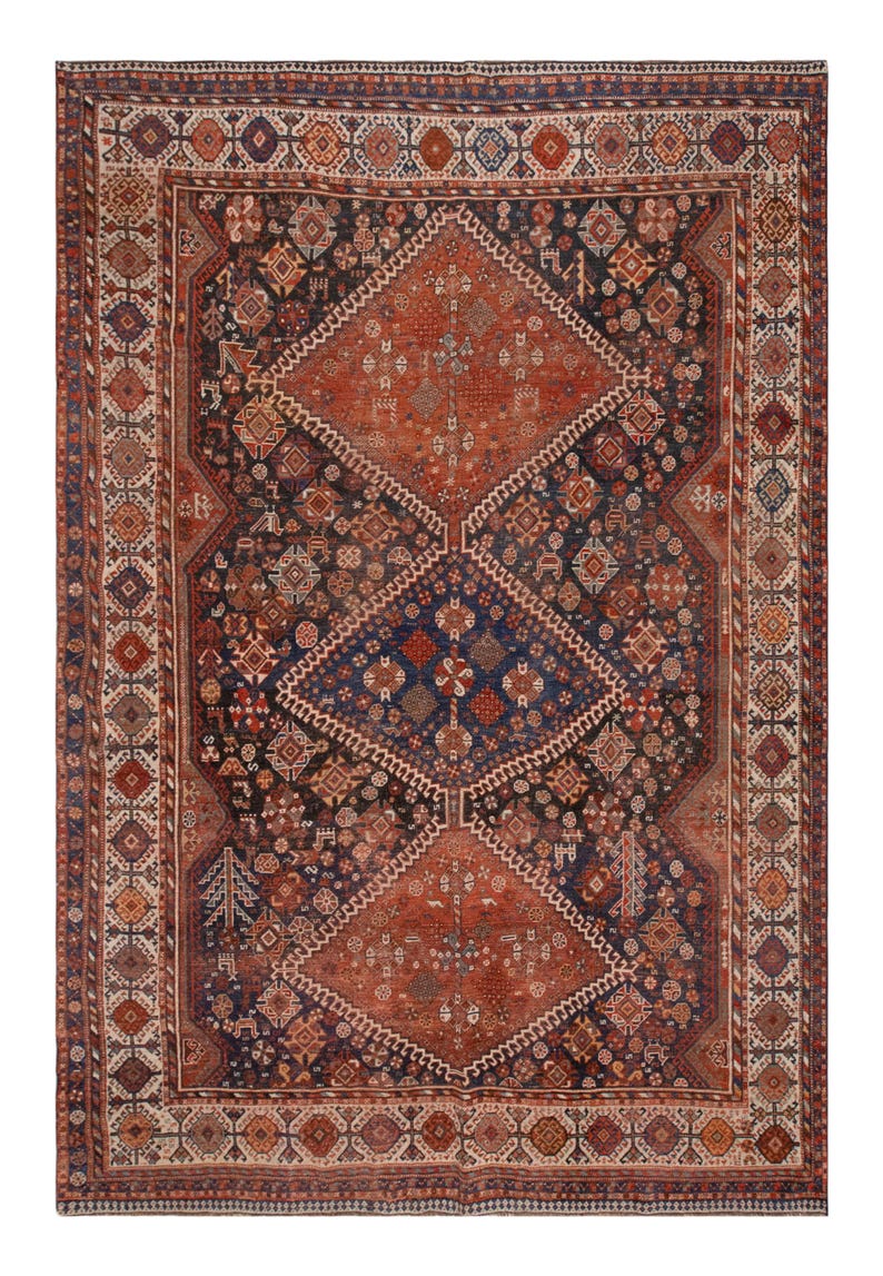 May include: An antique Persian rug with a complex geometric design. The rug features a central diamond pattern in shades of rust and navy blue, surrounded by a detailed border. The intricate patterns and rich colors create a classic, timeless aesthetic.