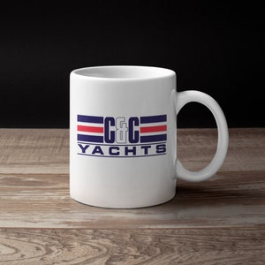 Peut inclure: Une tasse en céramique blanche avec un logo bleu et rouge qui dit "C&C YACHTS".