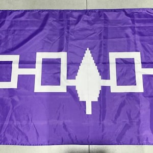 May include: A purple flag with a white stylised tree in the centre and a white design of connected squares above and below the tree.