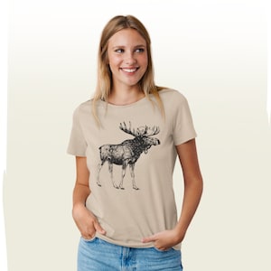May include: A beige t-shirt with a black and white illustration of a moose on the front.