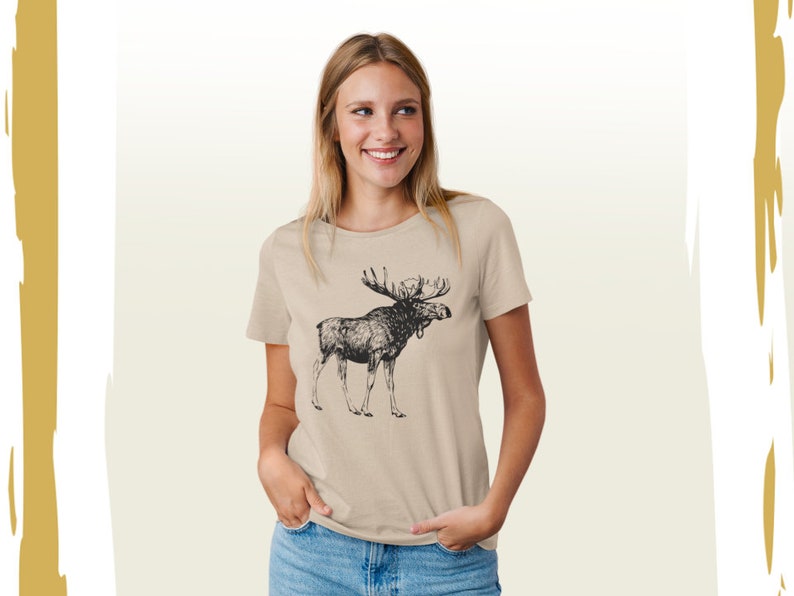 May include: A beige t-shirt with a black and white illustration of a moose on the front.