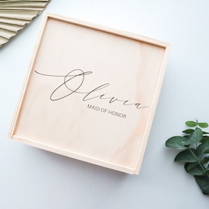 May include: A wooden box with the name "Olivia" and the title "Maid of Honor" engraved on the top.