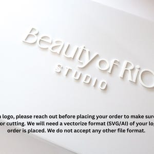 Może przedstawiać: Białe pudełko z nadrukowanym tekstem "Beauty of Rio Studio" na g&oacute;rze. Pudełko zawiera r&oacute;wnież instrukcje dotyczące zam&oacute;wień niestandardowych logo, wskazując, że do cięcia wymagany jest format wektorowy (SVG/AI).