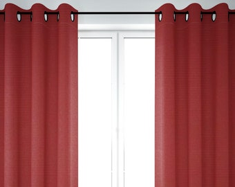 May include: A pair of red curtains with grommet tops hanging on a window rod.