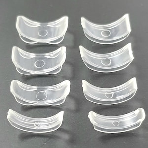 May include: Eight clear plastic rings with a small hole in the centre. The rings are arranged in two rows of four.