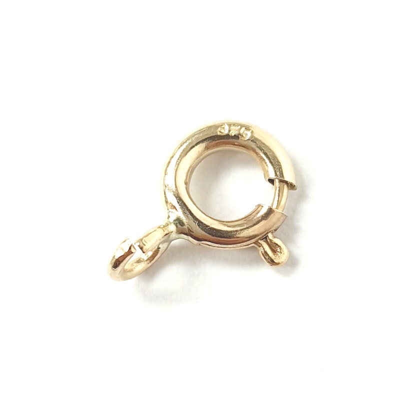 May include: Gold-toned metal clasp with a spring-loaded closure. The clasp is designed to be used for attaching jewelry or other items.