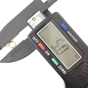 May include: A close-up of a digital caliper measuring 5.0 mm. The caliper is black with a digital display and buttons labeled "OFF", "ON", and "ZERO".