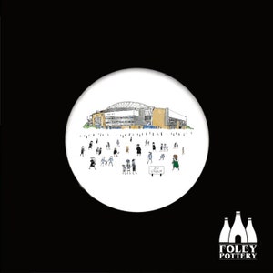 May include: A white ceramic coaster featuring a black and white illustration of a stadium with people in front of it. The stadium has a sign that reads "DW Stadium".