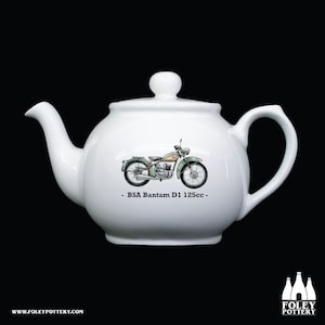 Könnte beinhalten: Weiße Keramik-Teekanne mit einer grün-braunen Illustration eines BSA Bantam D1 125cc Motorrads. Der Text "BSA Bantam D1 125cc" ist unter dem Motorrad aufgedruckt.