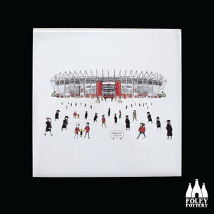 May include: A black and white illustration of a stadium with people walking towards it. The stadium is red and white with a sign that reads "Riverside Stadium".
