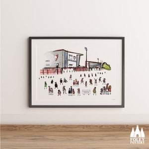 Puede incluir: Una ilustración dibujada a mano de un estadio con una multitud de personas con camisetas rojas y blancas. El estadio está etiquetado como "The Valley" y el cartel frente a la multitud dice "Kingsholm Stadium".