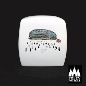 May include: White ceramic box with a black and white illustration of a stadium with people walking around it. The stadium is labeled "White Hart Lane".
