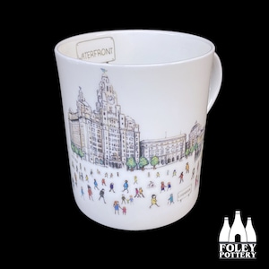 May include: White ceramic mug with a black and white illustration of the Liver Building in Liverpool, England. The mug has the words "WATERFRONT" and "LIVERPOOL" printed on it.
