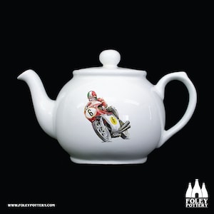 Könnte beinhalten: Weiße Keramik-Teekanne mit einem Design aus rotem und weißem Motorrad und Fahrer. Der Fahrer trägt einen Helm und das Motorrad hat die Nummer 6.