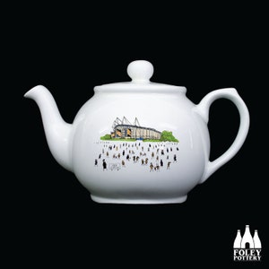 Może przedstawiać: Biały ceramiczny czajnik z czarno-białym rysunkiem stadionu z ludźmi na trybunach. Na czajniku nadrukowany jest napis "City Stadium".