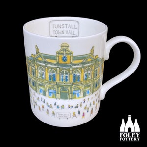 May include: White ceramic mug with a colorful illustration of the Tunstall Town Hall building. The mug has a black handle and the text "Tunstall Town Hall" is printed on the front.