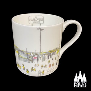 Könnte beinhalten: Weiße Keramiktasse mit einer Schwarzweißillustration eines Stadions mit dem Text "The Envirovent Stadium".