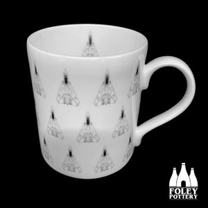 May include: White ceramic mug with a black and white repeating pattern of fighter jets. The mug has a handle and the text "FOLEY POTTERY" is printed on the bottom.