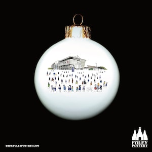 May include: White Christmas bauble featuring a hand-drawn illustration of a stadium with a crowd of people in front of it. The text "AZ Bell Stadium" is visible on the bauble.