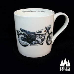 Puede incluir: Taza de cerámica blanca con una ilustración en blanco y negro de una motocicleta Velocette Venom 1955 500cc. El texto "Velocette Venom 1955 500cc" está impreso en la taza.