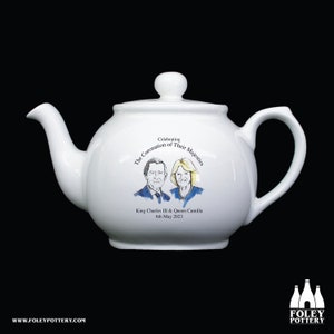 May include: White ceramic teapot with a hand-painted image of King Charles III and Queen Camilla. The teapot has the text "Celebrating The Coronation of Their Majesties King Charles III & Queen Camilla 6th May 2023".