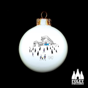 May include: White ceramic Christmas bauble featuring a black and white illustration of a stadium and people walking towards it. The text "Selhurst Park" is visible on the bauble.