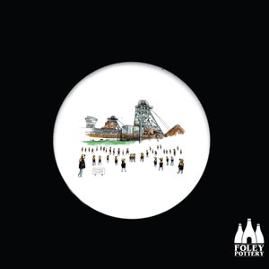 May include: A white ceramic coaster featuring a black and white illustration of a coal mine and a group of people wearing hard hats. The text "WITCHURCH COLLIERY" is visible on the coaster.