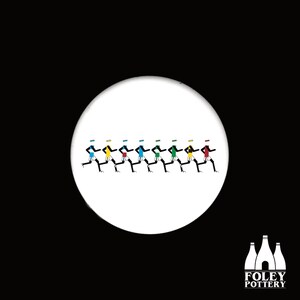 May include: A white ceramic coaster featuring a design of eight black stick figures running in a line. The figures are wearing different coloured shirts: yellow, green, blue, red, black, green, blue, and red. The coaster has the text "FOLEY POTTERY" in black letters at the bottom.