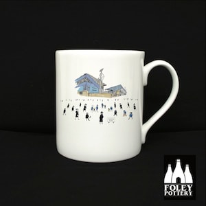 May include: White ceramic mug with a black and white illustration of a stadium and people walking. The text "FORMAL FOOD" is on a sign in the illustration.