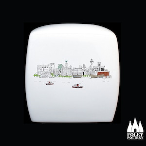 May include: White ceramic box with a black and white line drawing of the Liverpool skyline. The skyline includes the Liver Building, the Royal Liver Building, and the Anglican Cathedral. The box has a rounded top and a flat bottom.