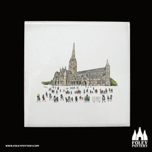 May include: A hand-drawn illustration of Salisbury Cathedral with a crowd of people in front of it. The cathedral is drawn in black and white with a gray roof. The people are drawn in various colors. The text "Salisbury Cathedral" is written on a sign in front of the cathedral.